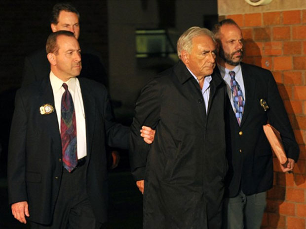 Algemado, Strauss-Kahn é escoltado por policiais na noite deste domingo (15), em Nova York. (Foto: Jewel Samad / AFP)
