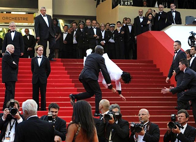 Segurança derruba um convidado que invadiu o tapete vermelho durante a cerimônia em homenagem ao ator francês Jean-Paul Belmondo durante o 64º Festival de Cannes, na França (Foto: AFP)