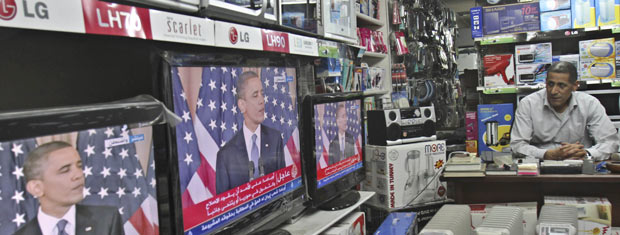 Palestinos assiste ao discurso de Obama nesta quinta-feira (19) em loja na Cidade de Gaza (Foto: AP)