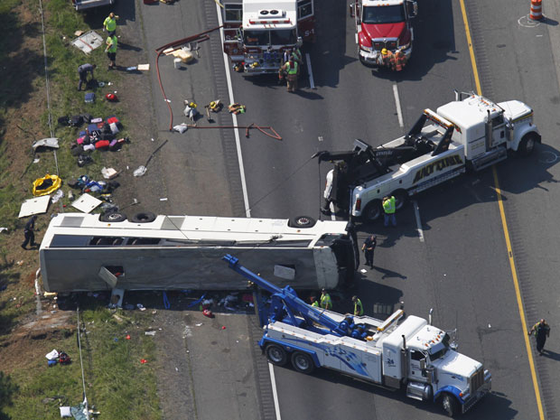 Imagem aérea mostra ônibus depois de puxado para a pista em estrada da Virgínia, nos EUA. O veículo capotou e saiu da pista na madrugada desta terça-feira (31) (Foto: AP)
