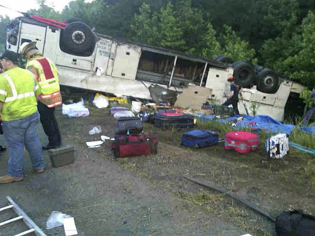 Um ônibus de turismo se acidentou e capotou na estrada I-95, próximo a Bowling Green, no estado americano da Virgínia. O veículo ficou com as rodas para cima, e quatro pessoas morreram. Vários passageiros ficaram feridos. (Foto: AP/Virginia State Police)