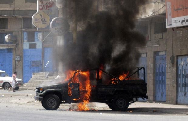 Carro da polícia é queimado durante confrontos nesta sexta-feira (3) na cidade iemenita de Taez (Foto: AP)
