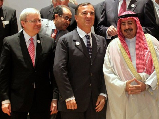 O chanceler italiano Franco Frattini entre os colegas do Kuwait, Mohammed al-Sabah (dir.), e da Austrália, Kevin Rudd (esq.), durante a foto oficial da reunião nos Emirados Árabes (Foto: Marwan Naamani / AFP)