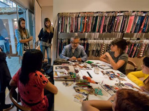 Estudantes de moda participam de workshop. Ao fundo, um catálogo de texturas e cores. (Foto: Divulgação)