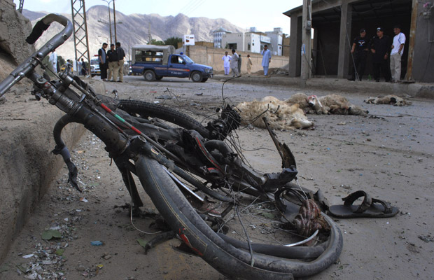 Polícia observa lugar de explosão de bomba na cidade paquistanesa de Quetta nesta segunda-feira (13). Uma bomba de ao menos 8 quilos foi plantada em uma bicicleta, e a explosão feriu duas pessoas e matou muitas ovelhas que passavam pelo local (Foto: AP)