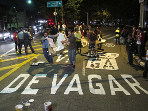 Manifestantes pintam o chão da avenida (Foto: Marcelo Mora/G1)
