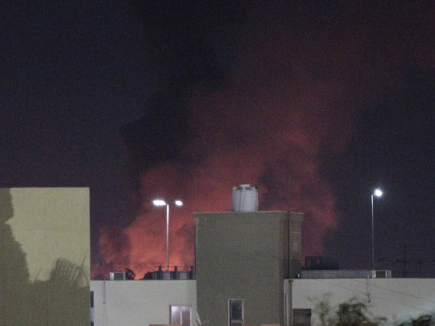 Fumaça e chamas erguem-se após bombardeio aliado a Trípoli, capital da Líbia, na noite desta terça-feira (14) (Foto: AP)