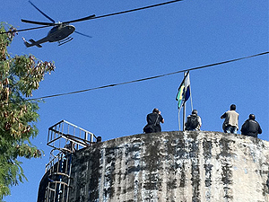 Policiais chegam ao alto do morro e fincam bandeiras do Brasil e do estado do Rio (Foto: Robson Bonin/G1)