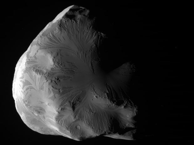 Imagens feitas pela sonda Cassini e divulgadas nesta terça-feira (21) pela Nasa mostram a lua Helene, de Saturno. Ela intriga pesquisadores porque, apesar de suas crateras, tem seu solo bastante plano.  (Foto: AP/Nasa)