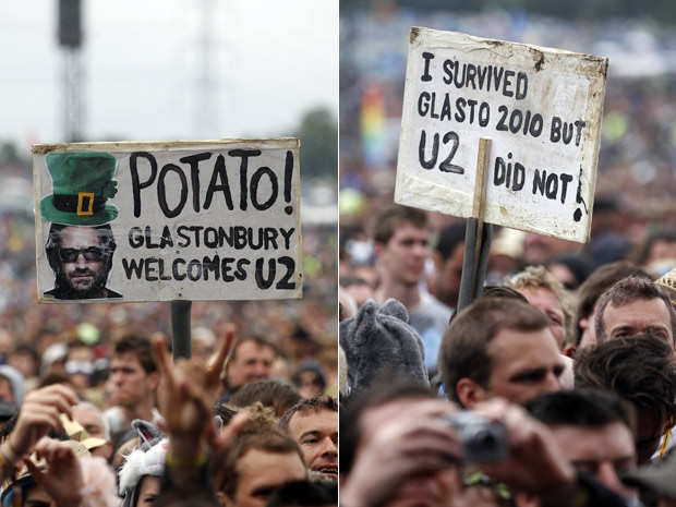 Frequentadores do Festival de Glastonbury carregam placas irônicas de 'boas vindas' à banda U2 (Foto: Reuters)