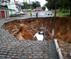 Carro é engolido por cratera em 
rua de Natal; internauta registra (Juliana Lopes de Aguiar / VC no G1)
