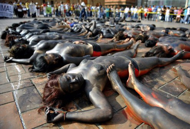Eles estavam seminus, com os corpos pintados de tinta preta e vermelha, para simbolizar um animal ferido (Foto: AFP)