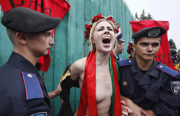 Ativista do grupo feminista ucraniano Femen protesta nesta terça-feira (5) ao ser detida durante ato em frente ao Parlamento, em Kiev (Foto: AP)