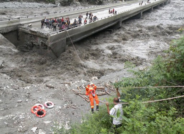 Bombeiros resgatam pessoas presas em ponte nesta segunda-feira (4) na China (Foto: Reuters)