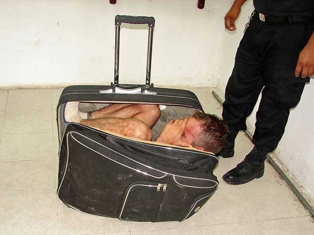 Homem se escondeu numa mala com a ajuda da namorada, mas plano foi descoberto pela polícia. (Foto: AP Photo)