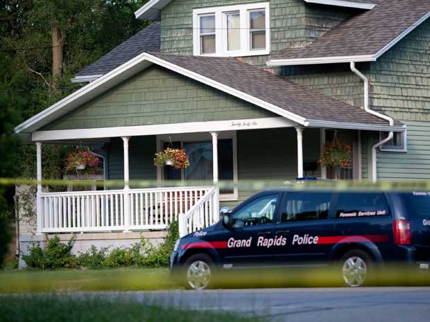 Polícia investiga uma das casas onde corpos foram encontrados em Grand Rapids. (Foto: Adam Bird / AP Photo)