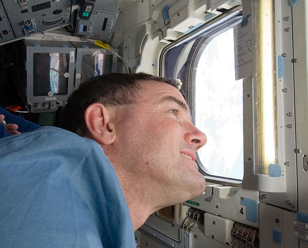 O astronauta Rex Walheim olha pela escotilha do Atlantis em direção à Terra (Foto: Nasa)
