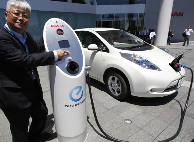 Engenheiro chefe da Nissan, Hidetoshi Kadota, mostra o novo sistema para recarregar carros elétricos (Foto: Koji Sasahara/AP)