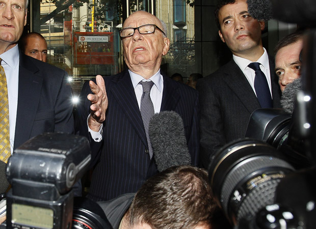 Rupert Murdoch tenta falar a jornalistas após reunião com os pais e a irmã de Milly Dowler nesta sexta-feira (15). Segundo o advogado da família, Murdoch pediu desculpas pelo fato de jornalistas do seu grupo terem grampeado os Dowler (Foto: AP)