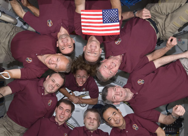 Astronautas posam com a bandeira história dos EUA na ISS (Foto: Nasa)