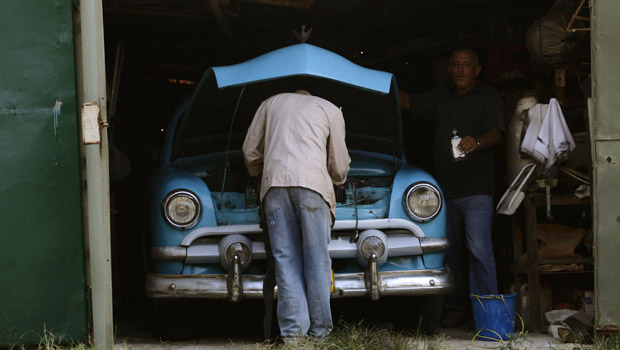 Cubano conserta Ford 1951 em rua da capital, Havana, nesta sexta-feira (29) (Foto: Reuters)