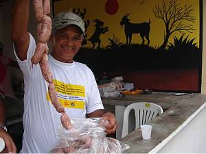 Carlos Alberto Duarte mostra linguiça de bode, entre outros alimentos derivados do animal, que são vendidos.  (Foto: Giselle Dutra/ G1 CE)