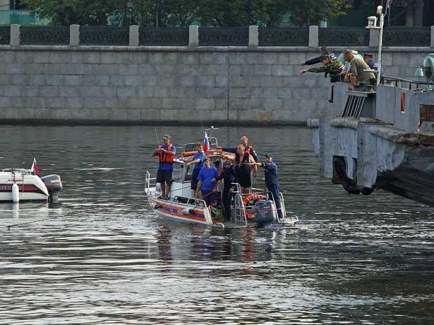 Equipes de emergência procuram sobreviventes após acidente que envolveu uma lancha e uma barcaça. (Foto: Mikhail Voskresensky / Reuters)