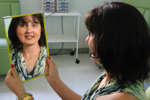 Elizabeth de Azevedo olha no espelho pela primeira vez com a peruca (Foto: Pedro Triginelli/G1)