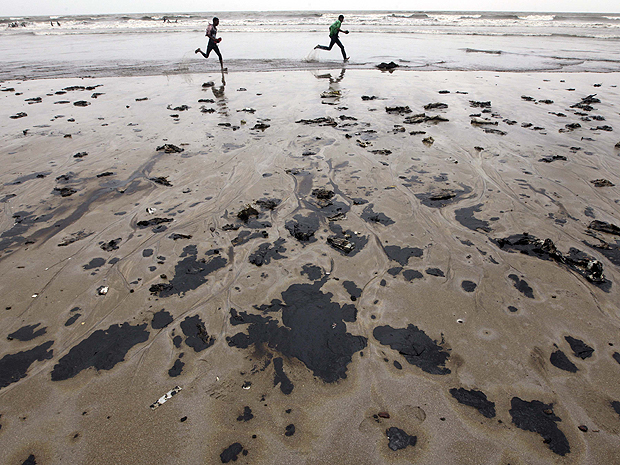 Praia de Juhu, na Índia, com óleo em sua orla (Foto: AP Photo/Rajanish Kakade)