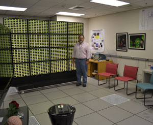 O gerente do projeto da IBM, Bill Risk, posa ao lado do que chama de 'parede cerebral'. Cada bloco representa um computador cognitivo com 256 neurônios (Foto: Divulgação)