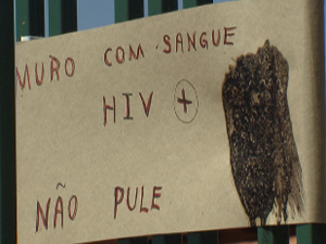 Cartaz colado em grade de casa do condomínio RK, em Sobradinho, avisa sobre seringas que teriam sangue com HIV (Foto: Reprodução/TV Globo)