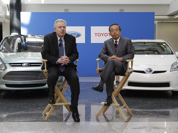 Derrick Kuzak (esq.), vice-presidente global de desenvolvimento do grupo Ford , e Takeshi Uchiyamada, vice-presidente executivo de pesquisa e desenvolvimento da Toyota Motor Corporation t, fecham acordo em Dearborn (Foto: Paul Sancya/AP)