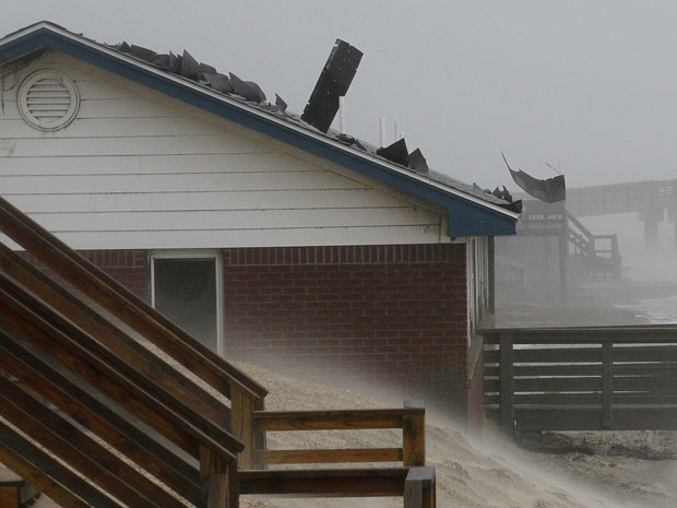 Enquanto a população de Nova Jersey se prepara para chegada do furacão Irene, efeito do fenômeno é sentido pela população da Carolina do Norte, onde a areia invadiu casas e o forte vento destrui telhados (Foto: Gerry Broome/AP) (Foto: Gerry Broome/AP)