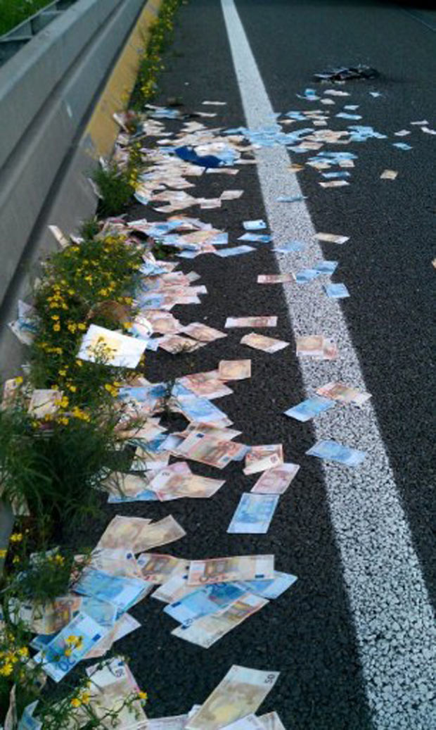 Caixa com as notas de dinheiro caiu de um carro forte. (Foto: Rudy Bouma/AFP)