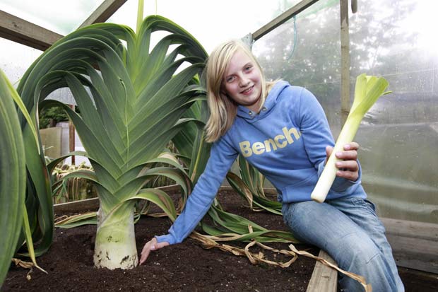 Lucy Skinner com o alho-poró que mais parece uma palmeira. (Foto: Nick Obank/Barcroft Media/Getty Images)