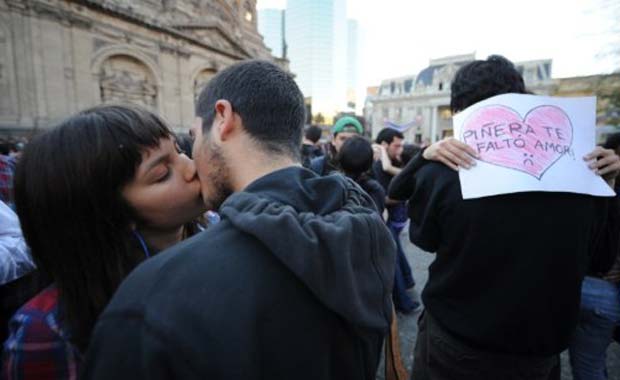 Estudantes beijam-se durante protesto contra o sistema de ensino nesta quinta-feira (1º) em Santiago do Chile (Foto: AFP)