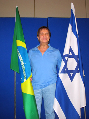 O cantor Roberto Carloss posa para fotógrafos entre as bandeiras do Brasil e de Israel. Rei concedeu entrevista coletiva em Jerusalém nesta quinta (1) (Foto: Henrique Porto/G1)