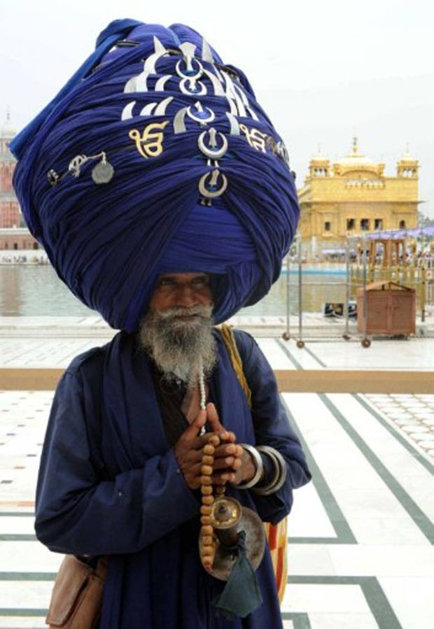 Um indiano foi flagrado na quinta-feira (1) em um templo em Amritsar, na Índia, usando um turbante que mede 300 metros de comprimento ao ser desenrolado. (Foto: Narinder Nanu/AFP)