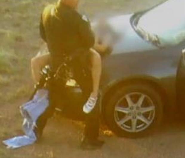 Policial foi flagrado fazendo sexo em serviço sobre o capô do carro.  (Foto: ReproduçãoI)