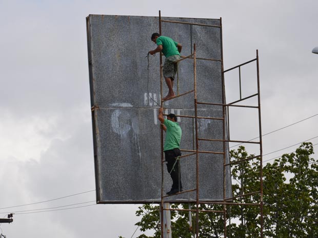 Homens trabalhando em placa de João Pessoa (Foto: Walter Paparazzo/G1)