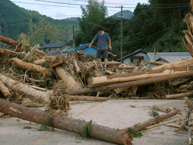 Homem passa nesta segunda-feira (5) por ponte destruída pelas chuvas em Kiho, na província japonesa de Mie (Foto: AP)