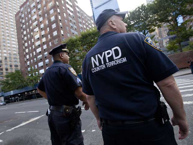 Policiais da divisão antiterrorismo de Nova York vistoriam carros nesta sexta-feira (9) (Foto: AP)