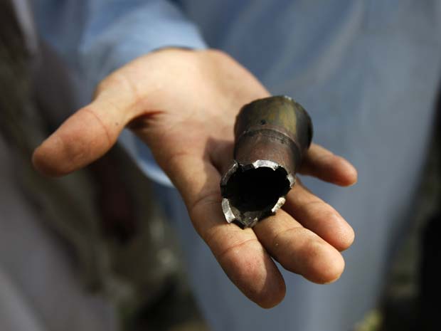 Homem mostra projétil lançado durante o ataque talibã desta terça-feira (13) no centro de Cabul, capital do Afeganistão (Foto: Reuters)