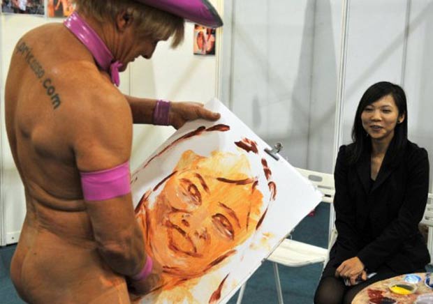Tim Patch faz retrato de jovem durante feira erótica em Macau, na China, em agosto. (Foto: Laurent Fievet/AFP)