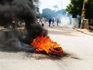 Protesto teve pneus queimados em via de Porto Príncipe nesta quarta (14) (Foto: AFP)