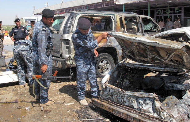 Policiais iraquianos inspecionam local de ataque com carro-bomba em Al-Hamza (Foto: Reuters)