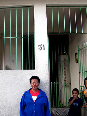 A diarista Maria das Graças da Silva posa em frente à casa que pode perder para o alargamento da Avenida itaquera (Foto: Raphael Prado/G1)