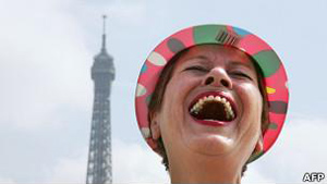 Turista em frente à Torre Eiffel em Paris: rindo à toa (Foto: AFP / via BBC)