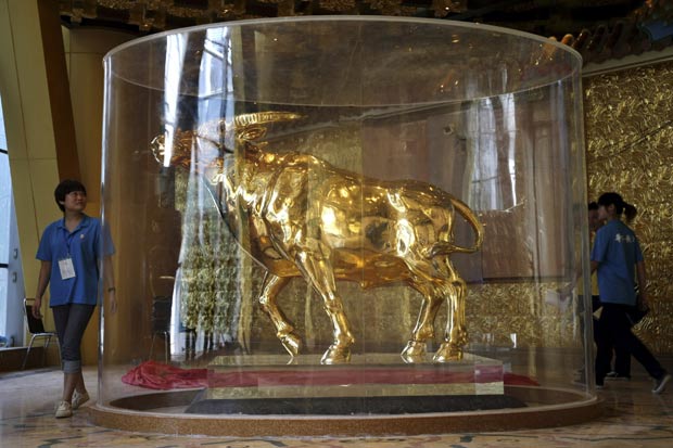 Prédio na China colocou escultura de touro feita com cerca de 1 tonelada de ouro. (Foto: AP)