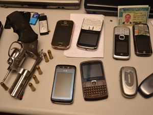 Arma e telefones foram apreendidos com suspeitos de roubo de carros de luxo (Foto: Walter Paparazzo/G1)